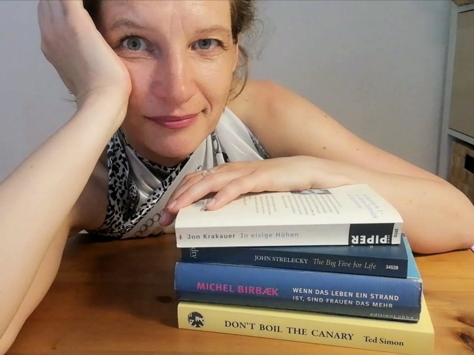 Frau (Eva Strehler) mit Bücherstapel